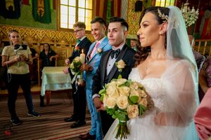 Traditional wedding ceremony unfolds in a richly decorated orthodox church with golden details.