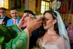 Wedding guests observe a ceremonial crown ritual in a beautifully lit church interior.