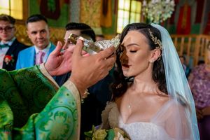 Wedding ceremony participants gather for traditional crown ritual in decorated venue.