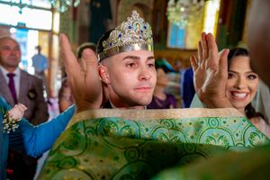 Traditional wedding ceremony with decorative green fabric and crown details in church setting.