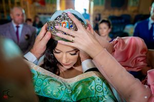 Wedding ceremony in progress inside a decorated church with green and gold accents.