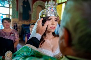 Wedding ceremony in an ornate church with colorful stained glass windows and traditional decor.