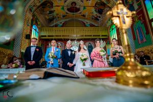 Wedding ceremony in an ornate venue with elegant decor and stained glass windows.