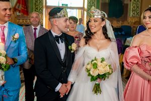 Wedding party members standing together in an elaborately decorated interior.