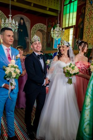 Wedding ceremony in a grand hall with emerald green lighting and ornate details.
