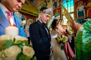 Wedding ceremony in an ornate room with colorful stained glass windows and decorative details.