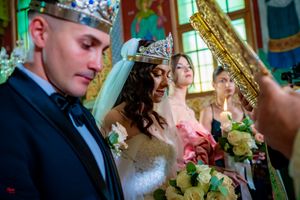 Intimate wedding ceremony moment in an ornate room with golden details and natural lighting.