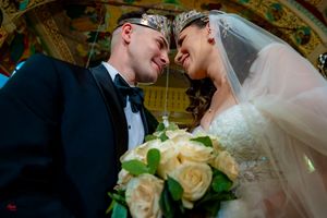 Intimate wedding moment captured in front of elaborate church iconography and golden decor.