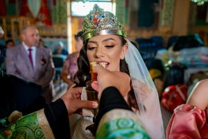 Ornate wedding venue with colorful stained glass windows and elegant chandeliers during a celebration.