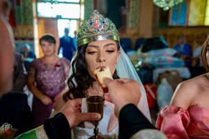 Wedding celebration in a beautifully decorated room with ornate ceiling and stained glass windows.