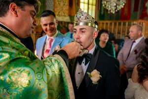 Wedding guests gathered in an ornate hall with painted ceiling and stained glass windows.