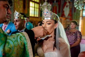 Wedding celebration inside historic venue with elaborate ceiling artwork and chandeliers.