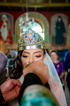 Bride wearing an ornate tiara and veil during traditional wedding ceremony.