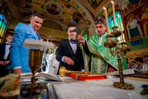 Orthodox priests in green vestments perform a religious ceremony at an ornately decorated altar.
