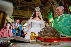 Traditional Orthodox wedding ceremony with priests in green vestments inside an ornate church.