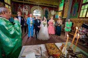Orthodox wedding service with attendees gathered in a richly decorated church interior.