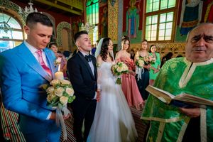 Religious ceremony in progress within a lavishly decorated orthodox church interior.
