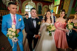 Wedding party gathered in an orthodox church with traditional iconography and green lighting.