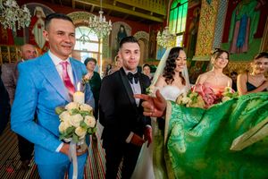 Wedding celebration featuring bright blue and pink attire in a traditional orthodox church.
