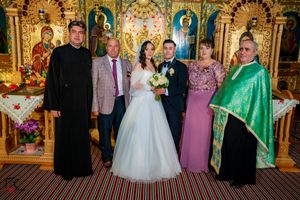Family wedding portraits taken in front of a decorative Orthodox church altar with golden details.