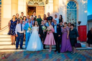 Wedding celebration group portrait on church steps during late afternoon.