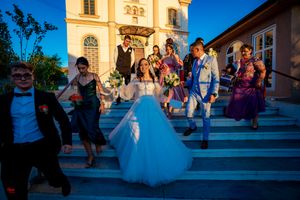 Evening wedding photography session outside historic church with guests.