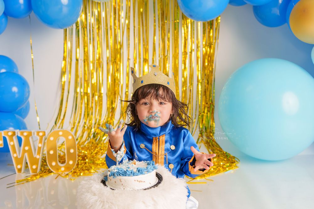 First birthday Smash Cake session with a baby enjoying and smashing a colorful cake. king