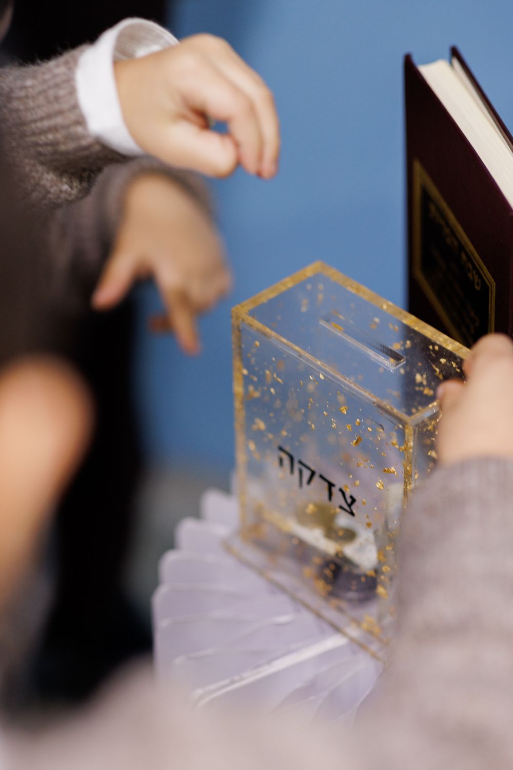 Hands demonstrating a clear acrylic box with gold accents being rotated in a sequence of motion shots.
