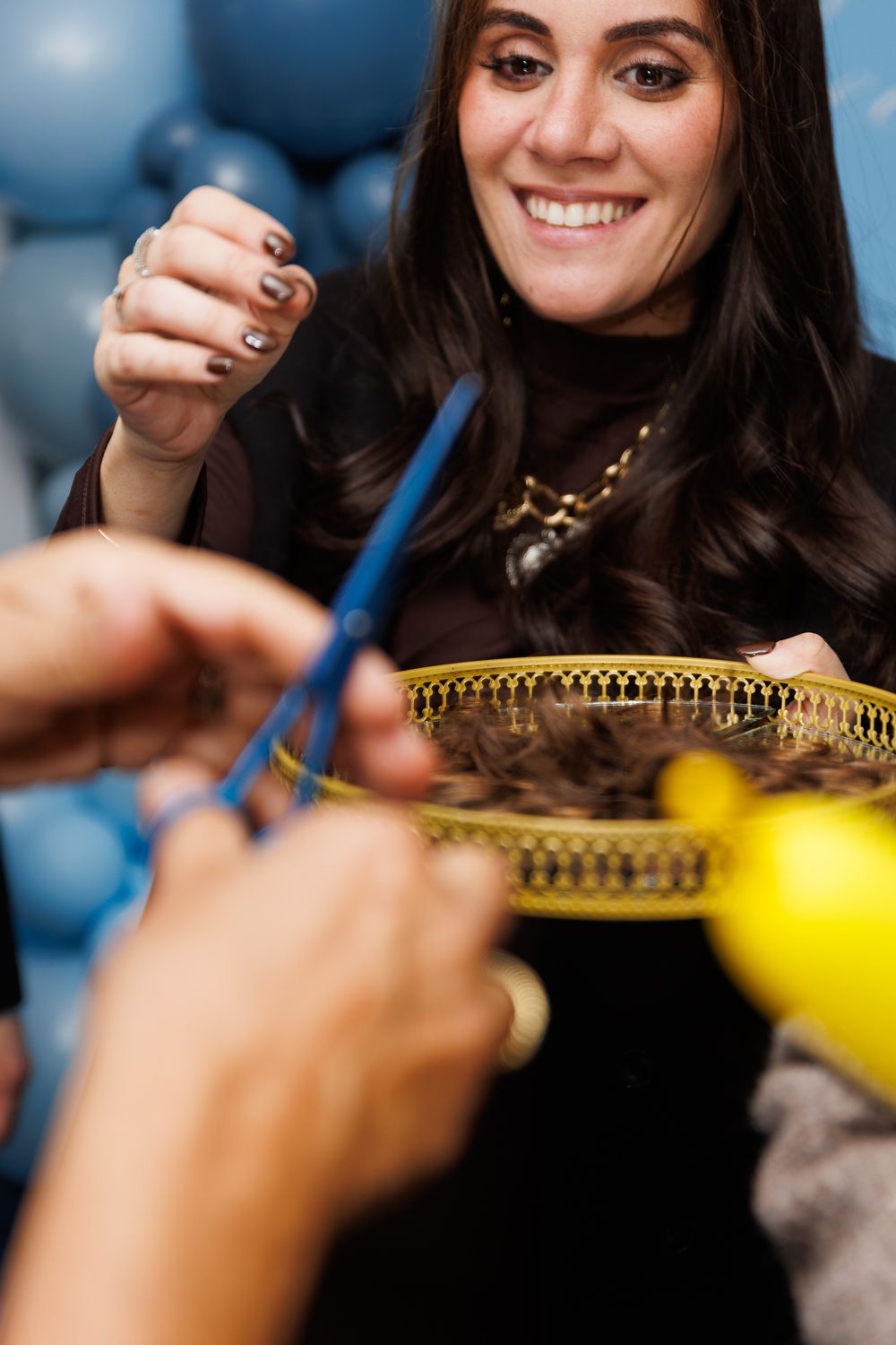 A series of close-up shots showing hands working on jewelry crafting with a blue tool against a blurred background.