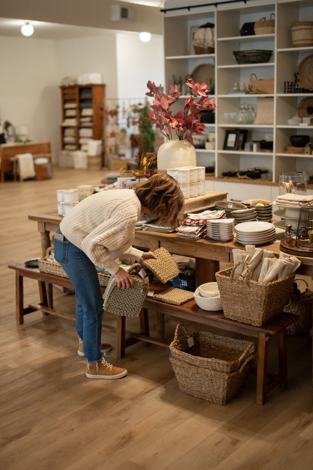 Interior view of retail space with wooden benches and woven baskets on display.
