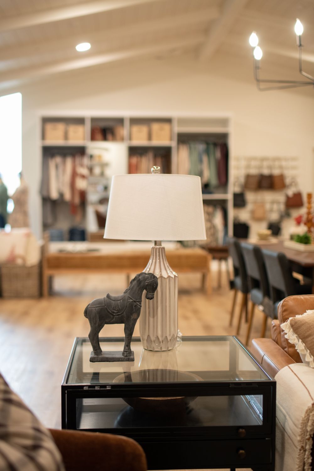 Modern interior with lamp, decorative horse figurine, and shelving displaying home decor items.