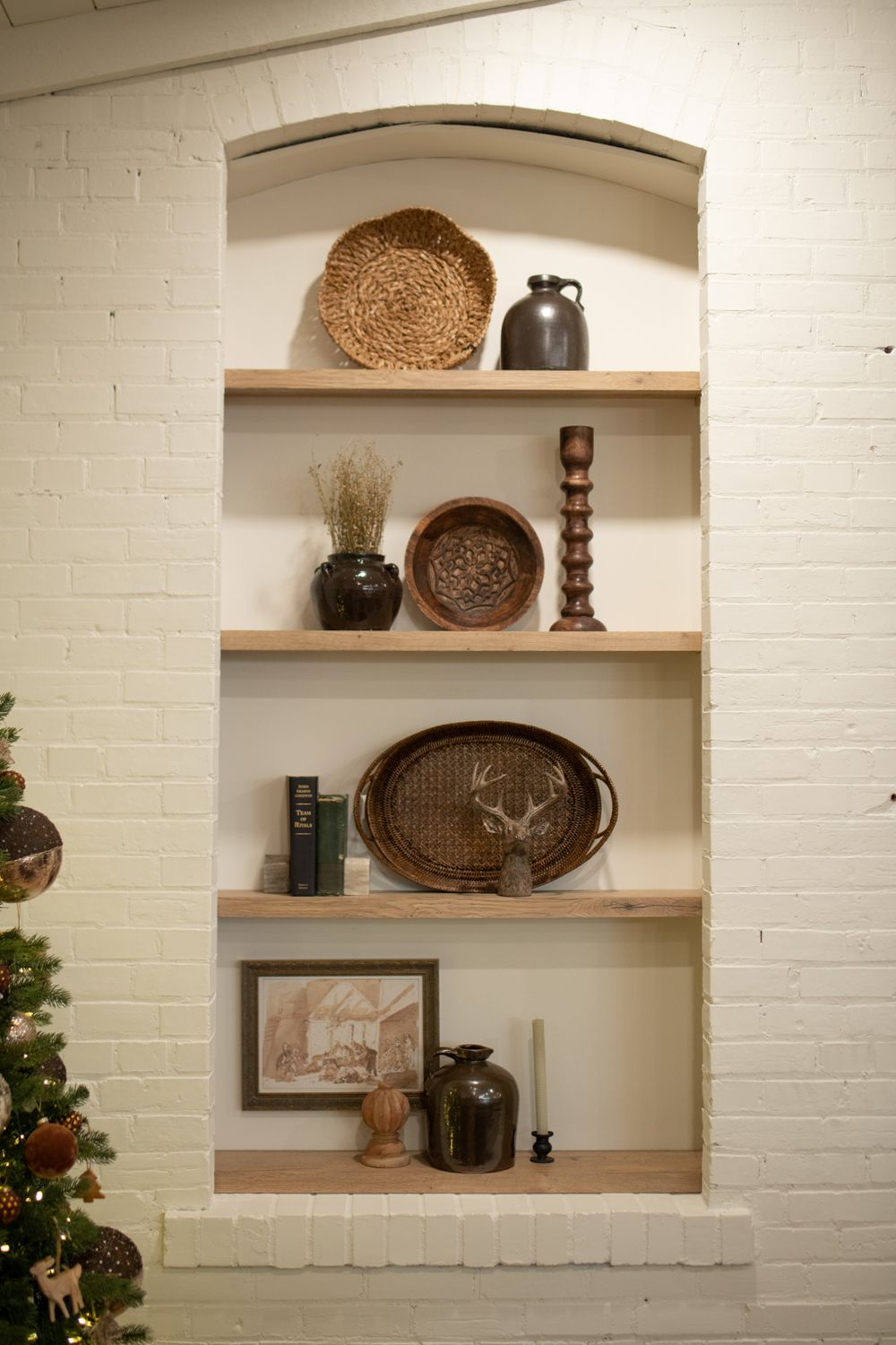 White brick built-in shelving displaying rustic decor and woven baskets.
