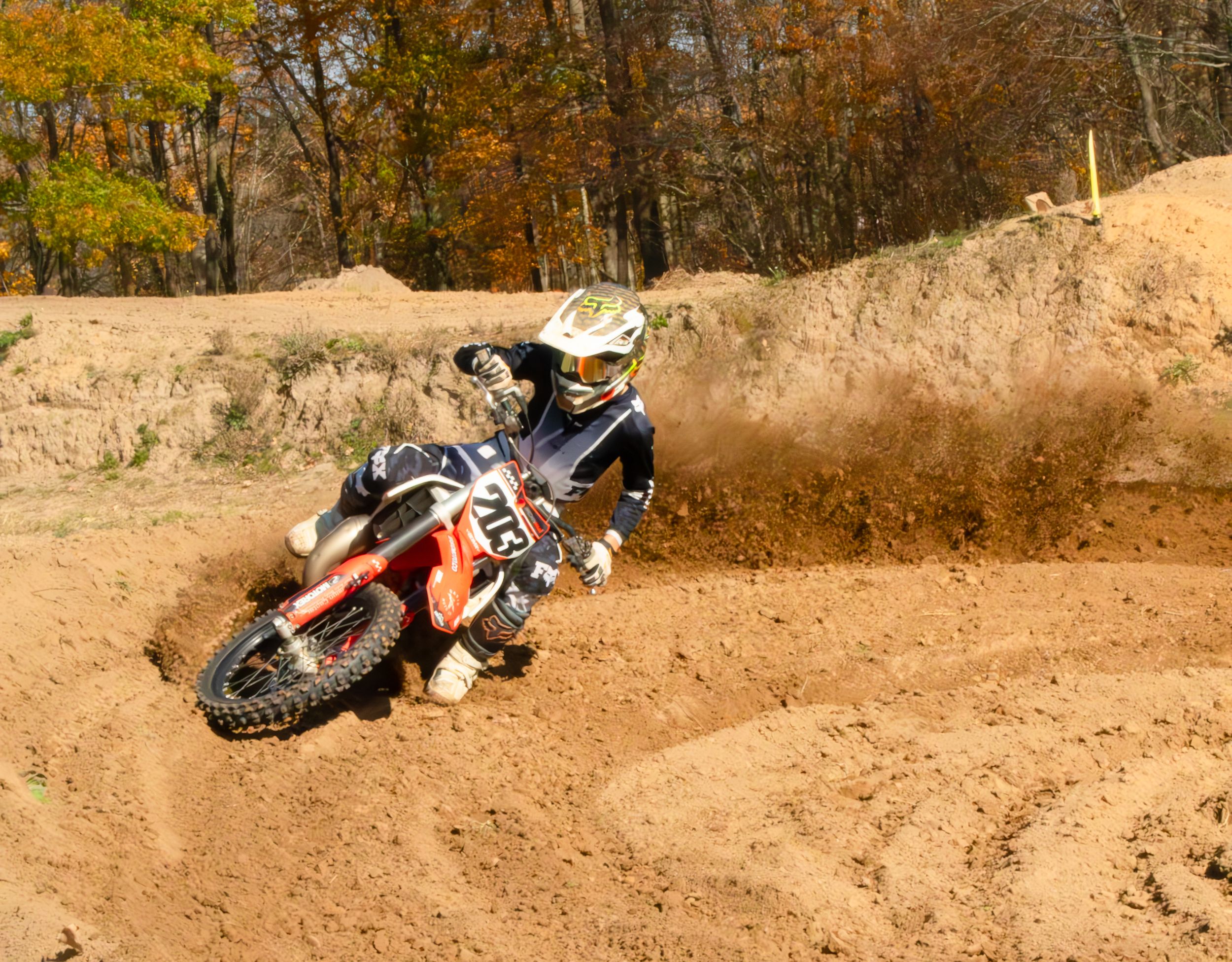 Motocross rider turning corner, dust flying