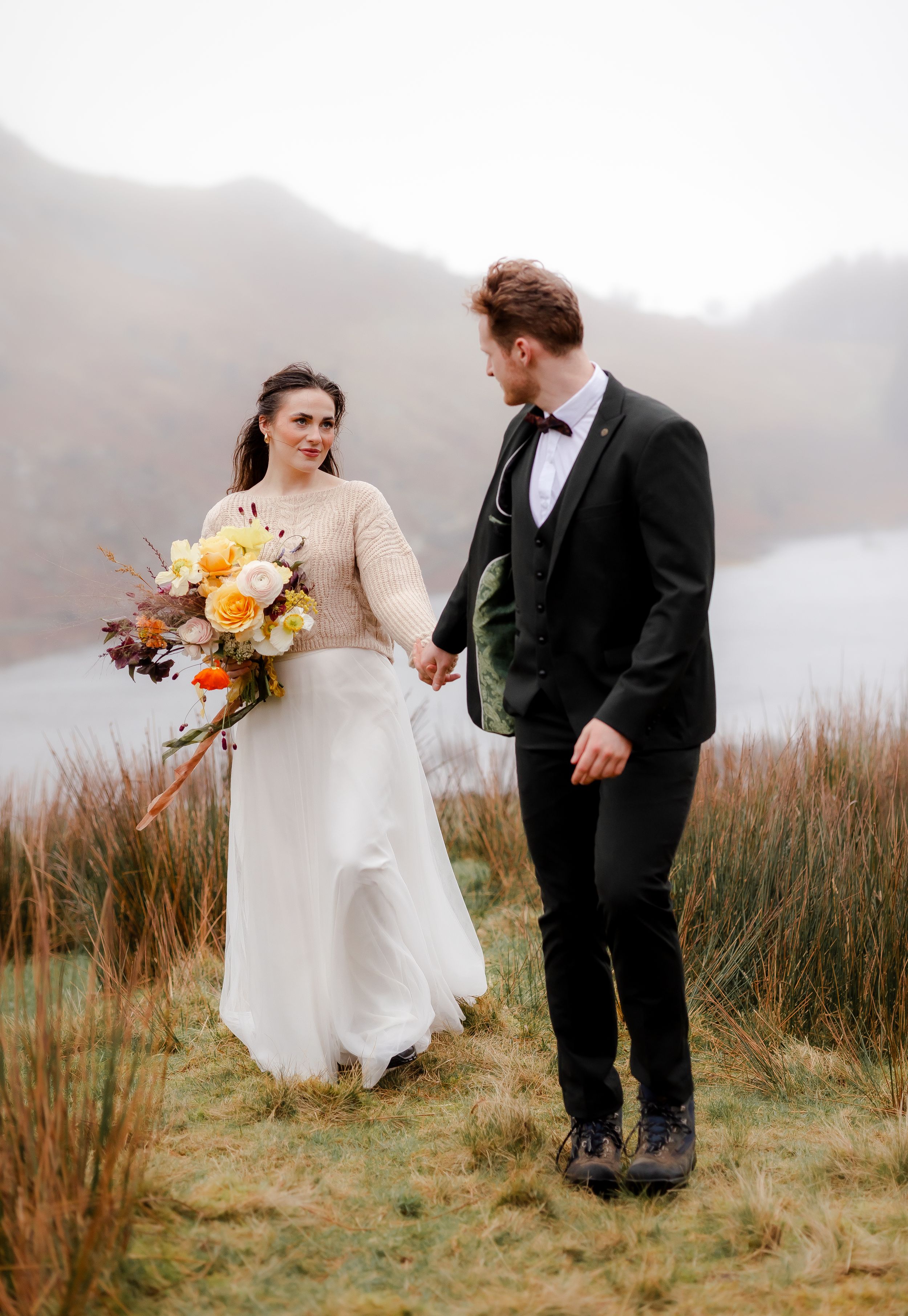Lake District Elopement photography - bride and groom walking the fells