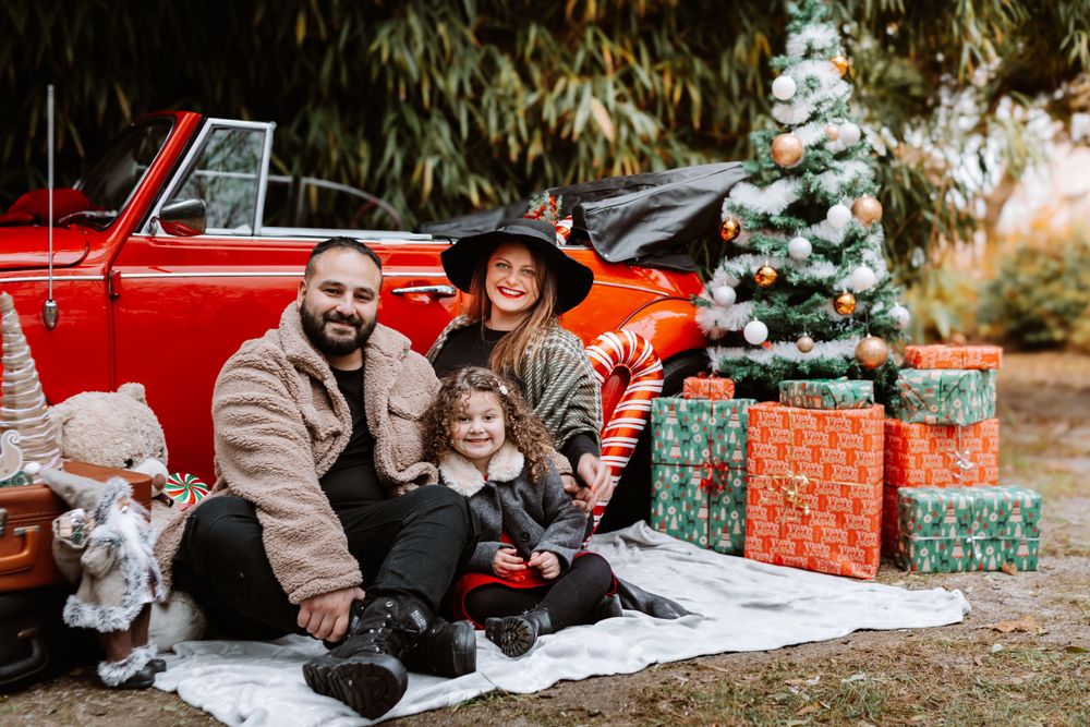 Mini-session photo de Noël 2024 avec une coccinelle VW rouge décorée pour les fêtes, créant une ambiance festive et chaleureuse.