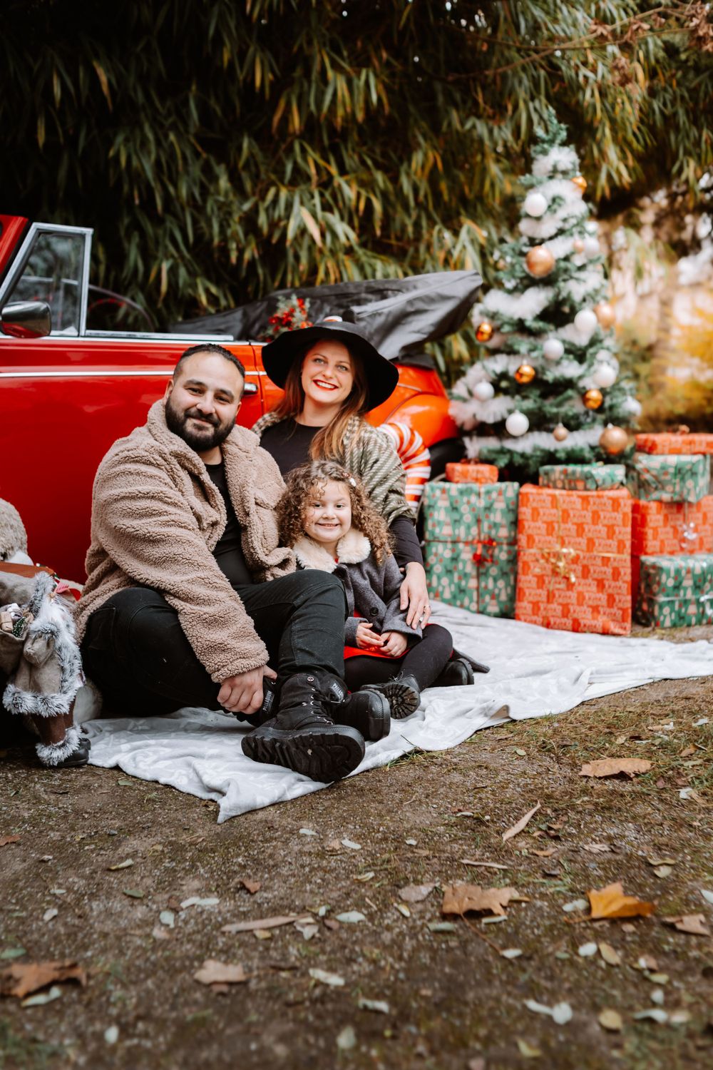 Mini-session photo de Noël 2024 avec une coccinelle VW rouge décorée pour les fêtes, créant une ambiance festive et chaleureuse.