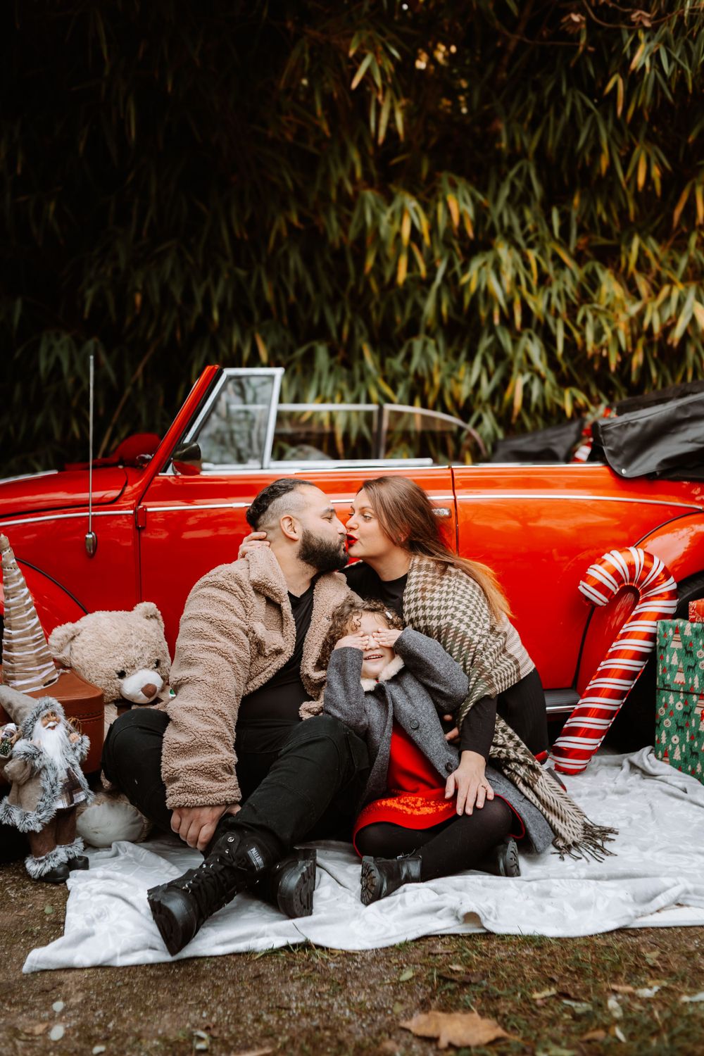 Mini-session photo de Noël 2024 avec une coccinelle VW rouge décorée pour les fêtes, créant une ambiance festive et chaleureuse.