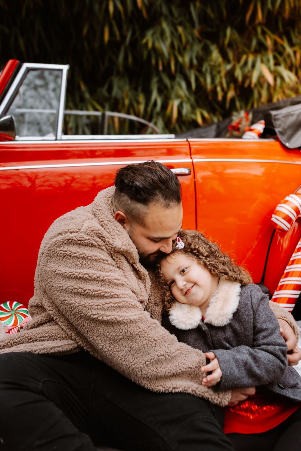 Mini-session photo de Noël 2024 avec une coccinelle VW rouge décorée pour les fêtes, créant une ambiance festive et chaleureuse.