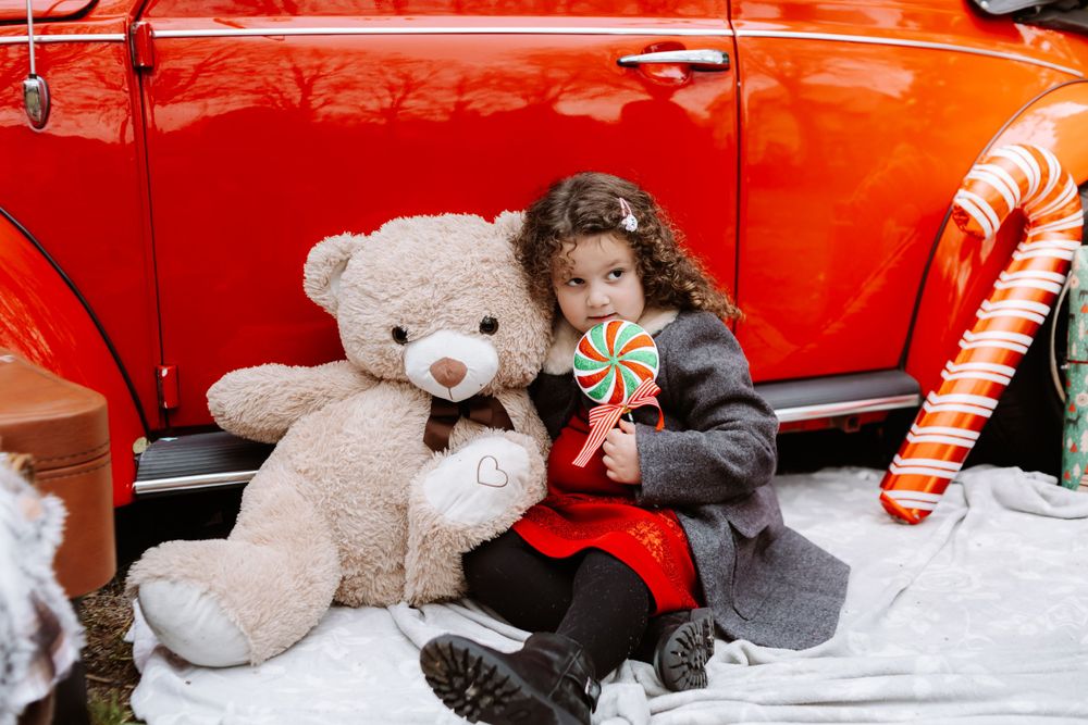 Mini-session photo de Noël 2024 avec une coccinelle VW rouge décorée pour les fêtes, créant une ambiance festive et chaleureuse.