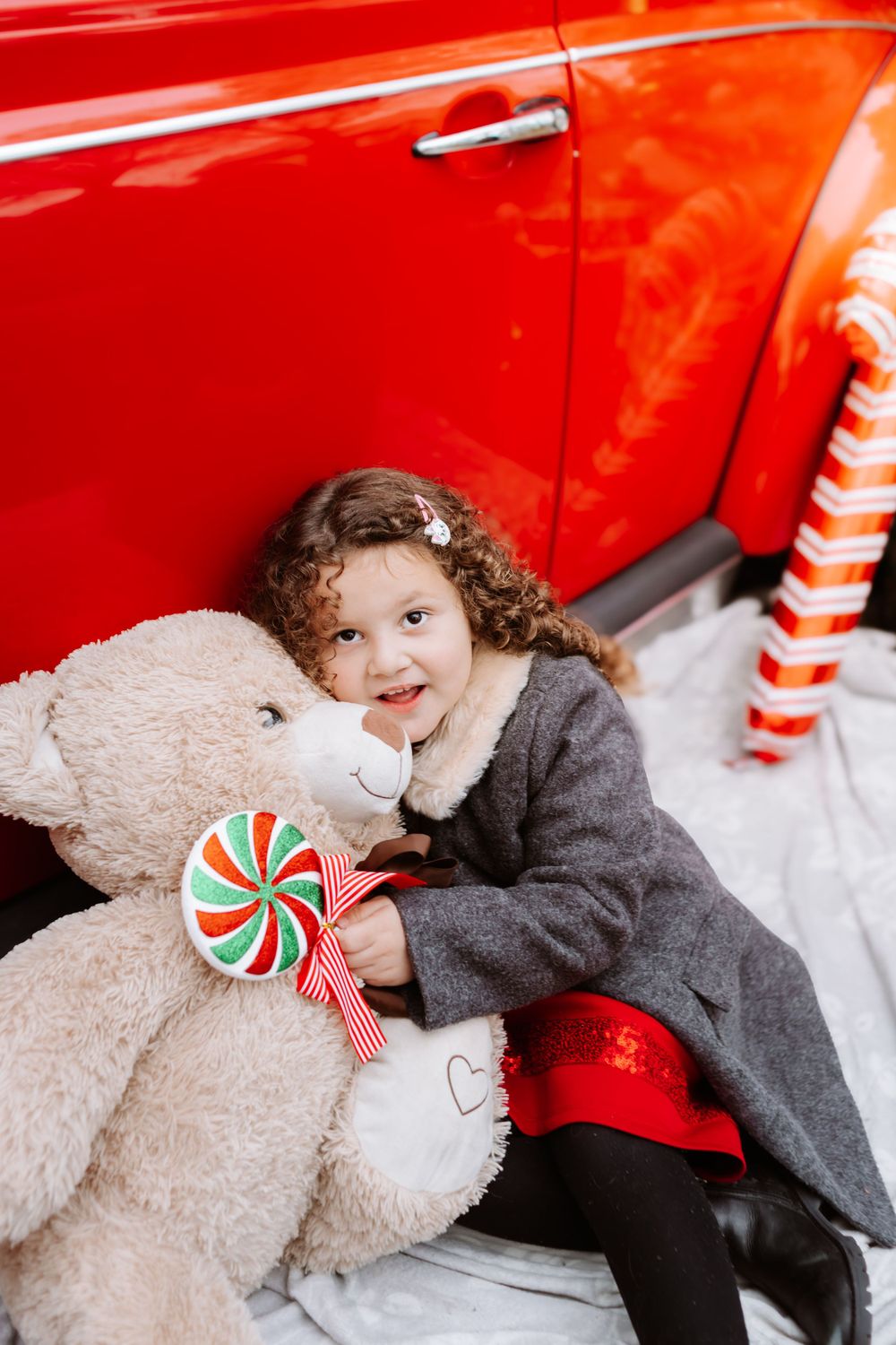 Mini-session photo de Noël 2024 avec une coccinelle VW rouge décorée pour les fêtes, créant une ambiance festive et chaleureuse.