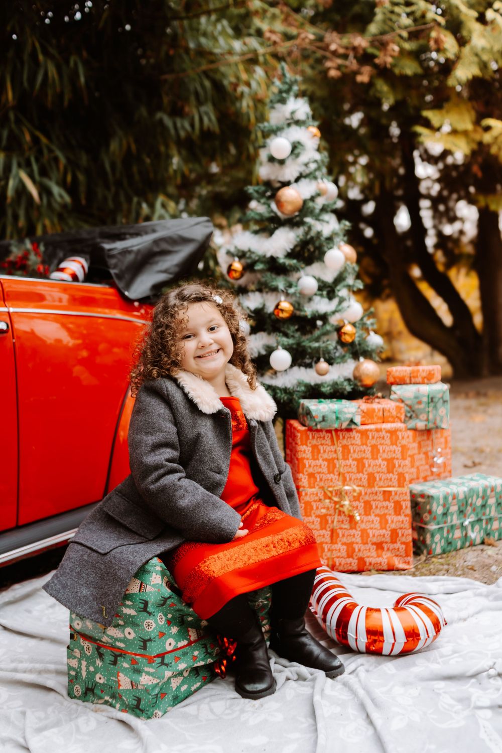 Mini-session photo de Noël 2024 avec une coccinelle VW rouge décorée pour les fêtes, créant une ambiance festive et chaleureuse.