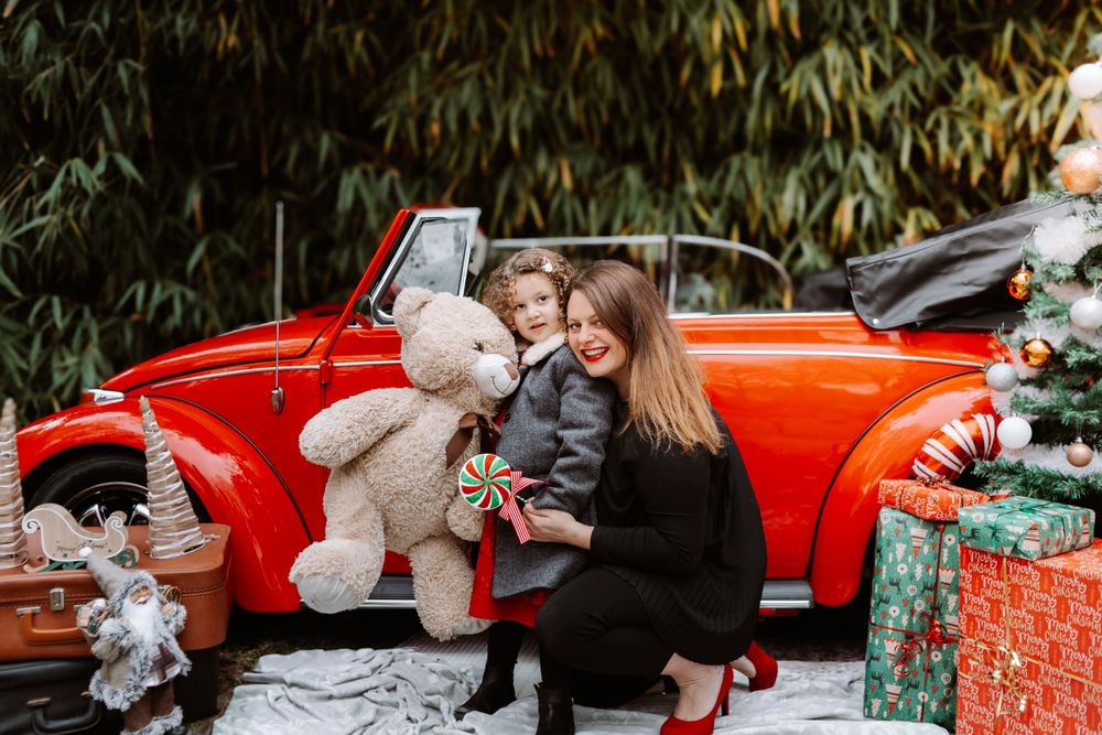 Mini-session photo de Noël 2024 avec une coccinelle VW rouge décorée pour les fêtes, créant une ambiance festive et chaleureuse.
