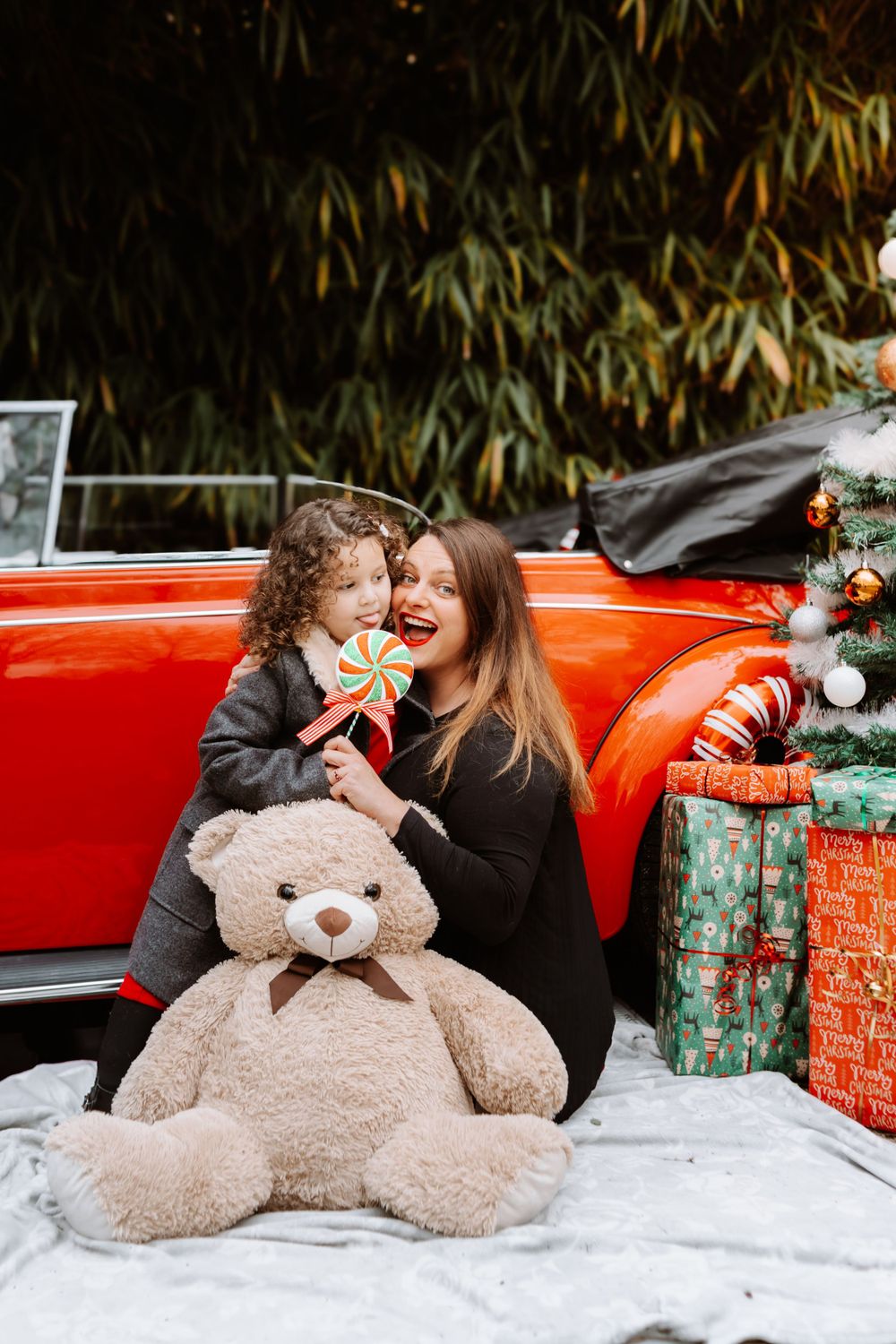 Mini-session photo de Noël 2024 avec une coccinelle VW rouge décorée pour les fêtes, créant une ambiance festive et chaleureuse.