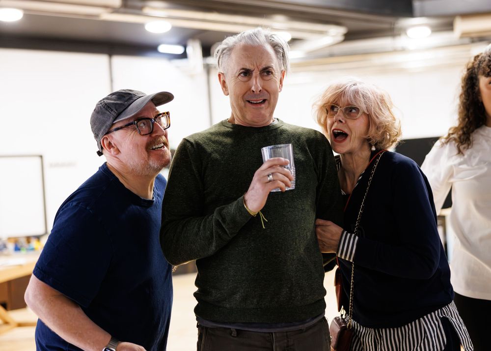 A group of people gather and smile together in what appears to be an indoor space.