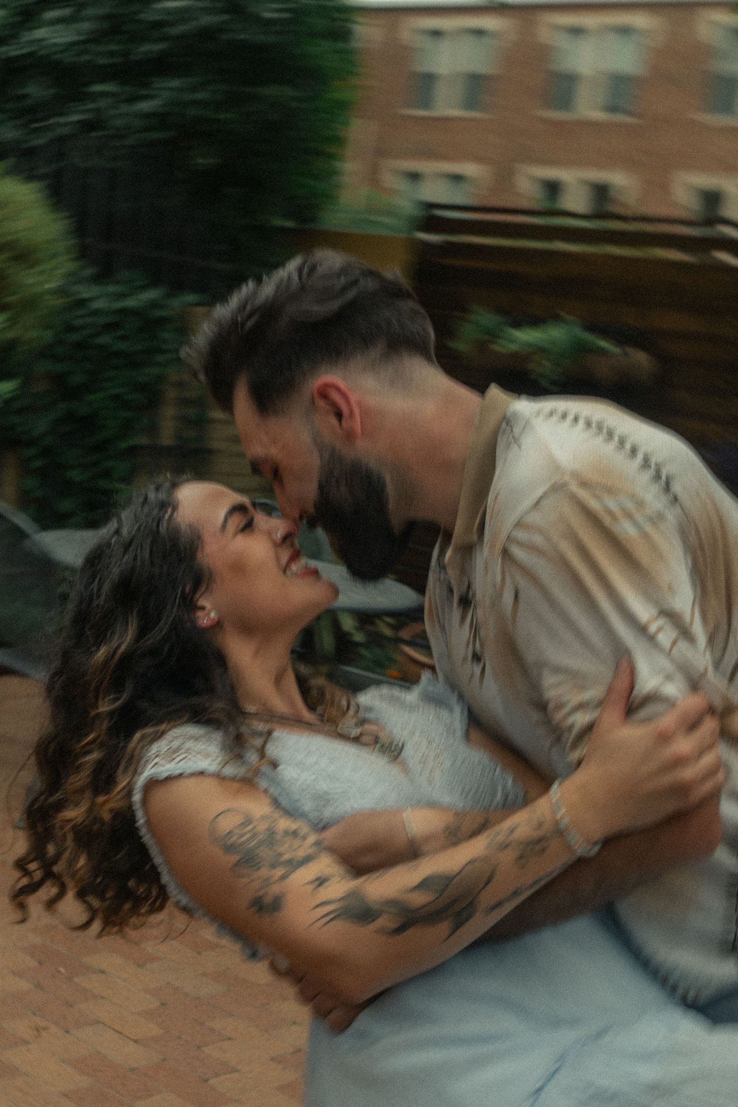 An intimate romantic moment captured in a garden setting with soft lighting.