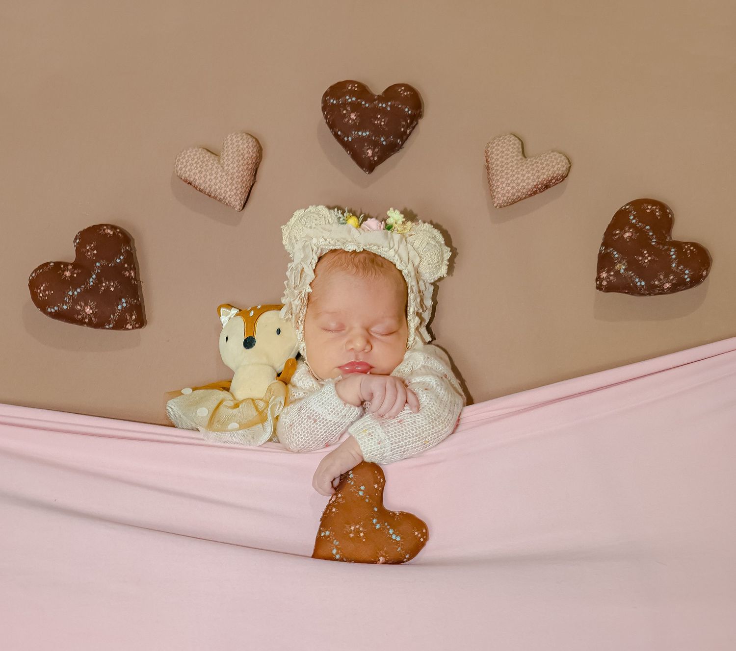 Rustic nursery decor with heart-shaped ornaments on beige wall.