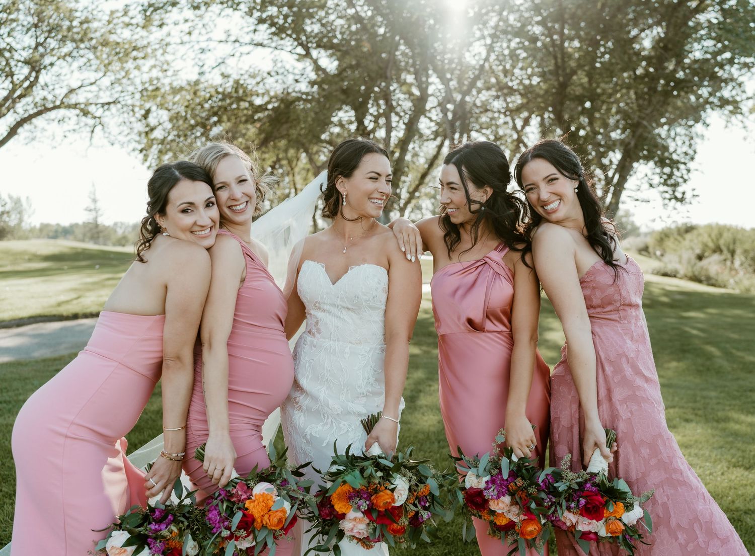 A bride and her four beautiful bridesmaids, hugging and having fun at an Okanagan-Similkameen wedding.