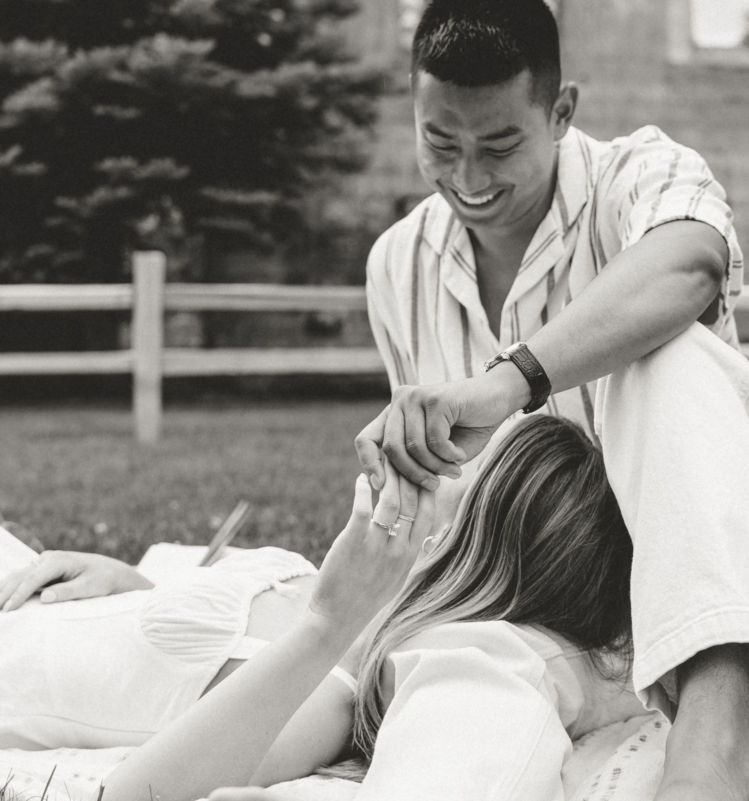 an intimate Okanagan-Similkameen engagement session, a smiling man looks lovingly at his bride to be while they picnic in the park.