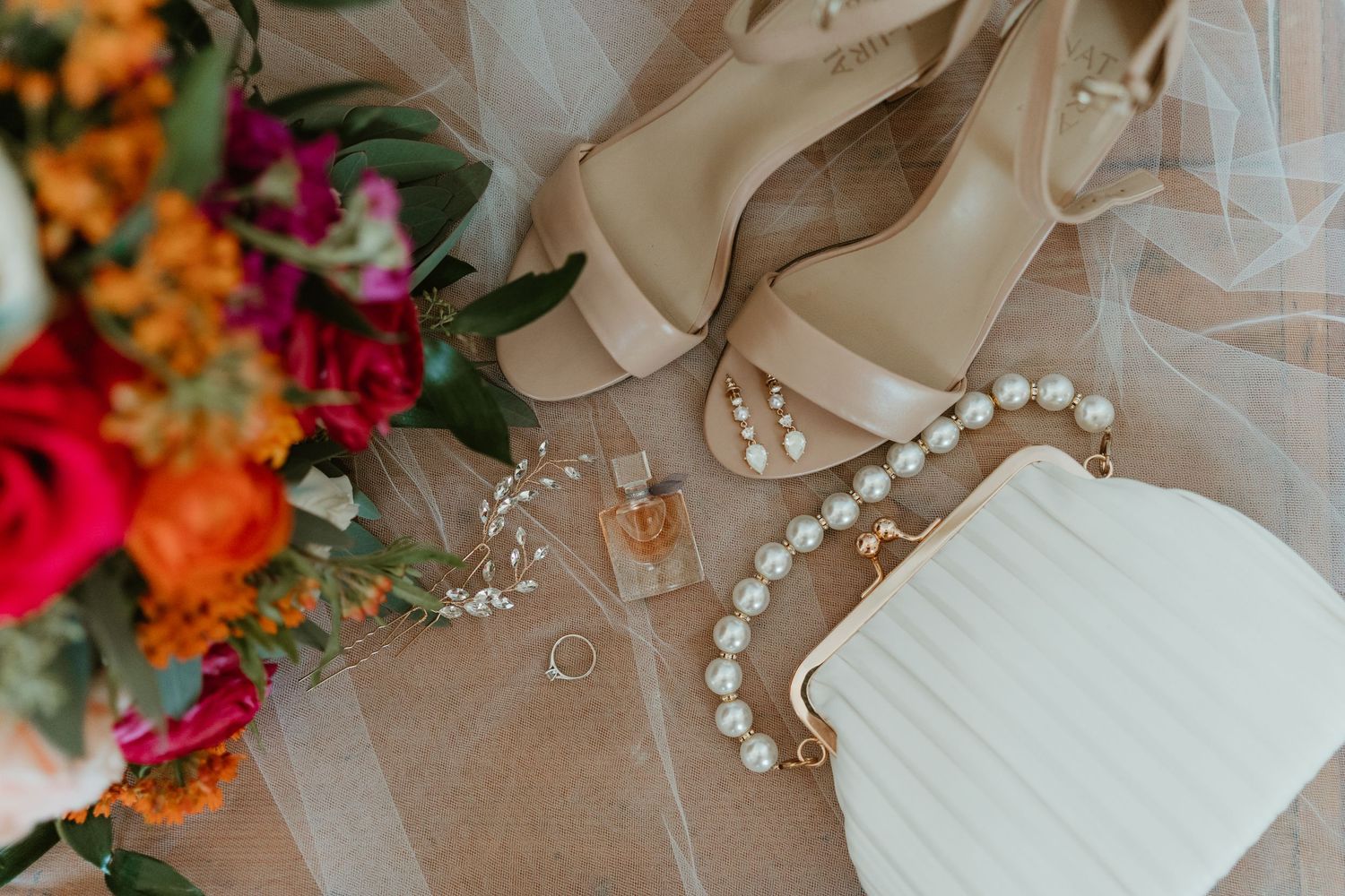 Classic, film style detail photos of a bride's ring, earrings, purse and perfume on her wedding day.