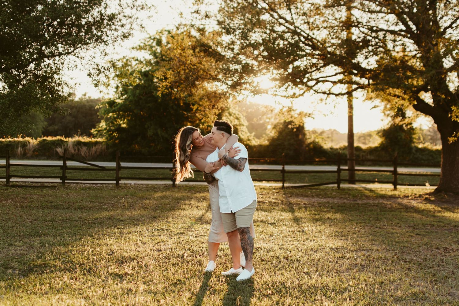 Golden sunlight illuminates a grassy field during sunset.